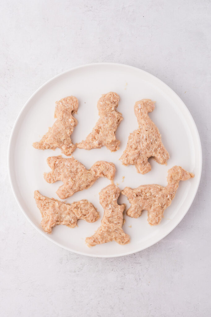 A plate of raw Air Fryer Dino Chicken Nuggets.