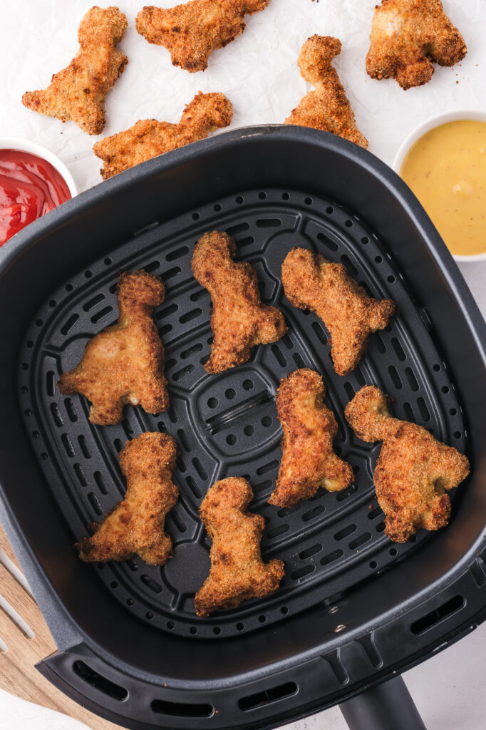 The cooked breaded Air Fryer Dino Chicken Nuggets in the basket of the air fryer.