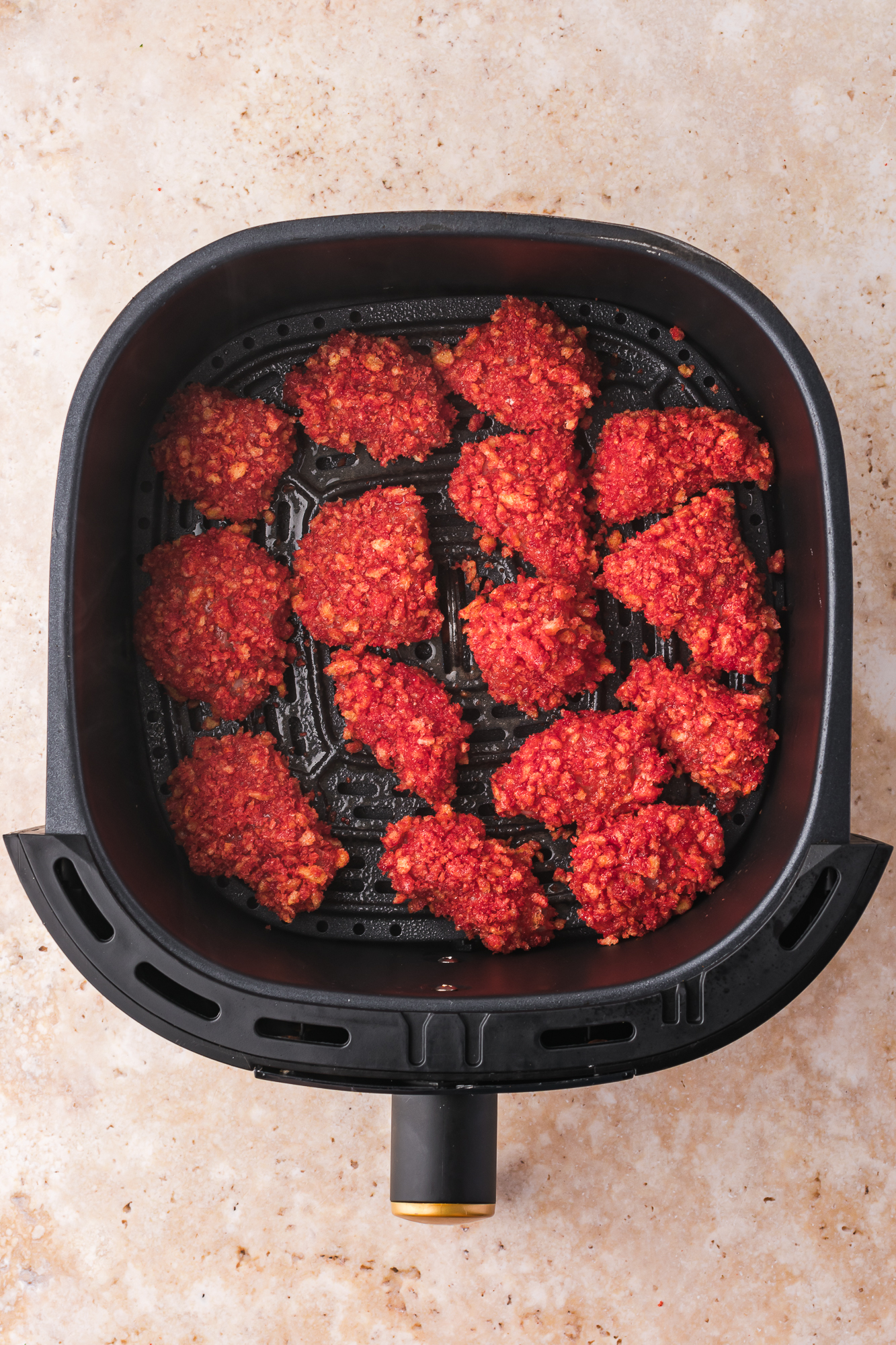 An air fryer basker full of Air Fryer Flamin' Hot Cheetos Nuggets.