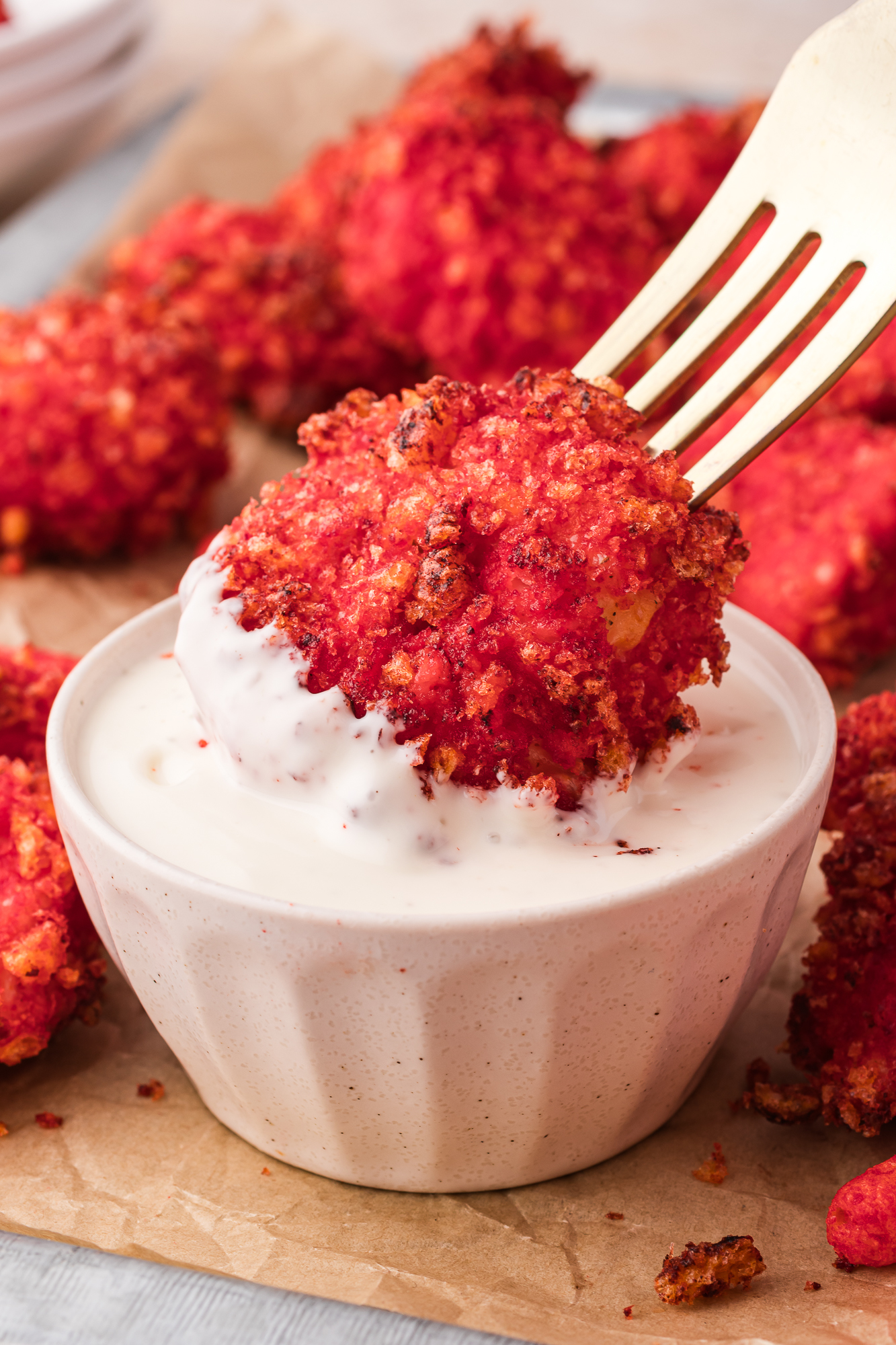 A close up of a Air Fryer Flamin' Hot Cheetos Nugget being dipped into ranch dressing.