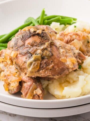 A plate of Slow Cooker Ranch Chicken with mashed potatoes and green beans.