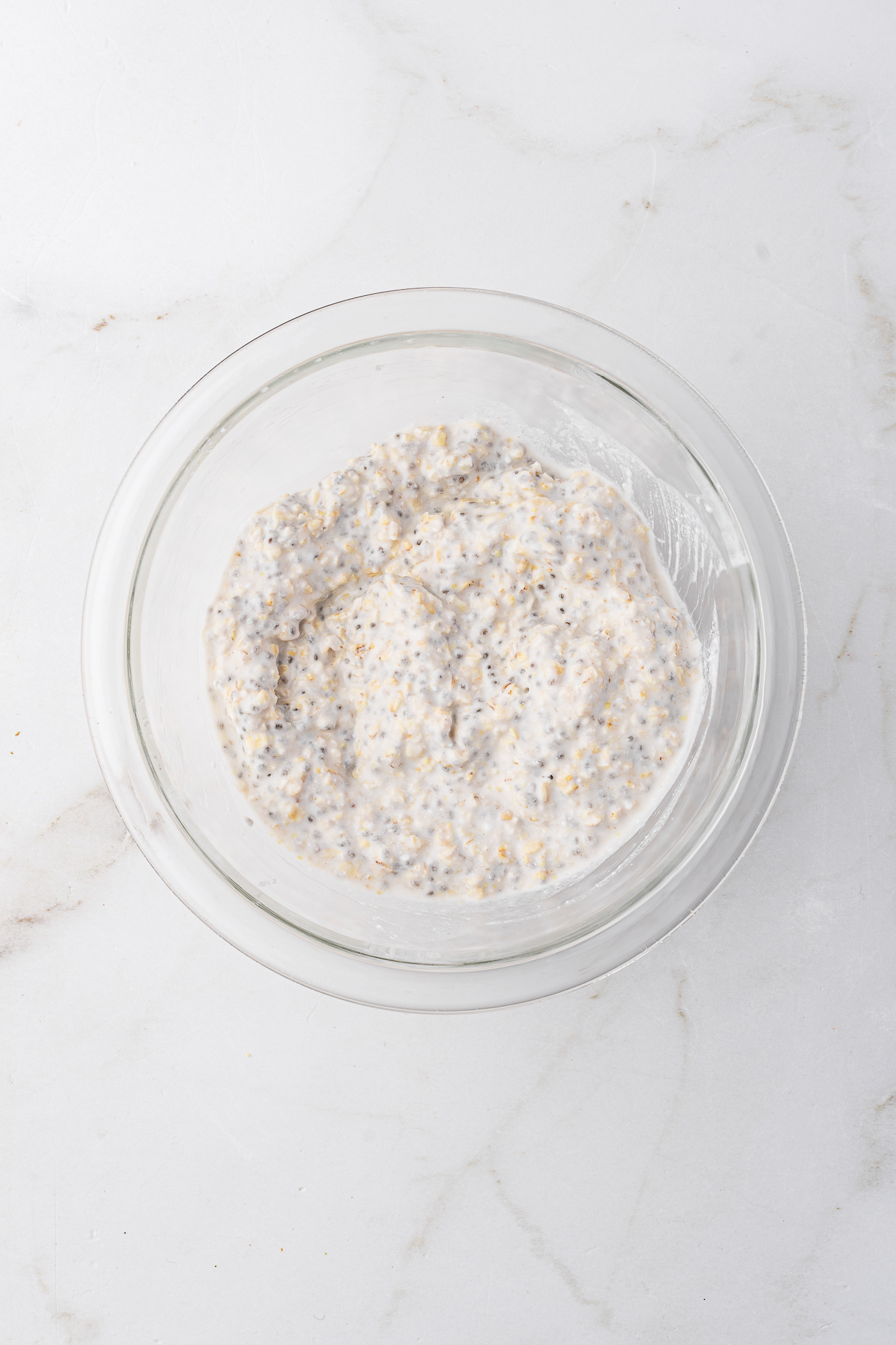 A glass bowl of the overnight oat mixture.