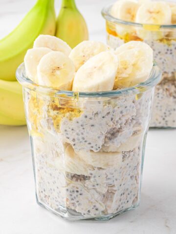 A jar of Banana Chia Overnight Oats next to a banana.