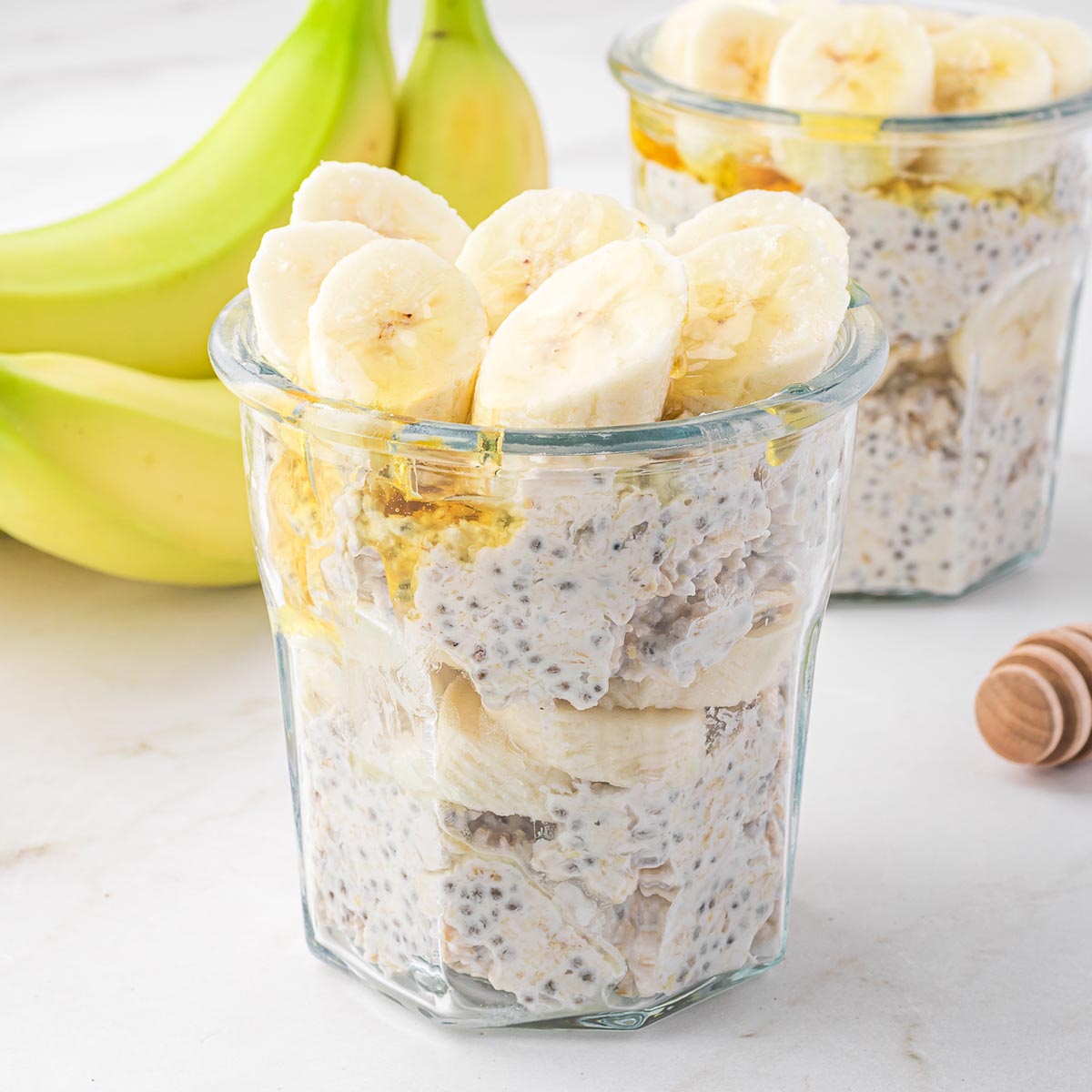 A jar of Banana Chia Overnight Oats next to a banana.