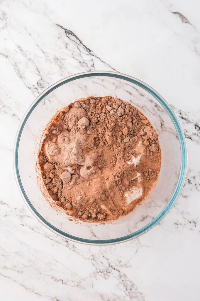 A bowl of unmixed Chocolate Protein Pudding ingredients.