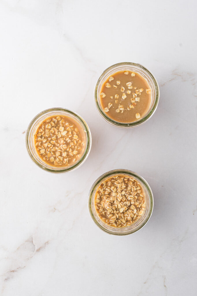 The overnight oat mixture divided into three smaller glasses.