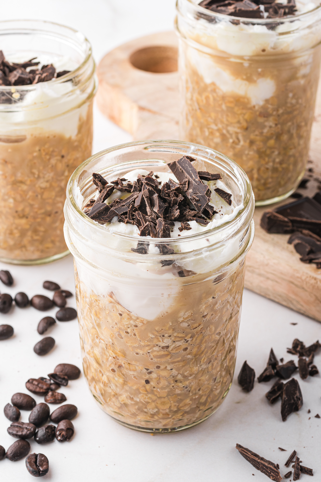 A close-up of a jar of Coffee Overnight Oats with Greek yogurt and chopped chocolate on top.