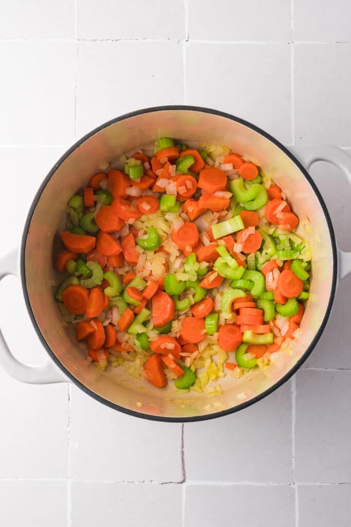 A pot of raw carrots, celery, and onion.