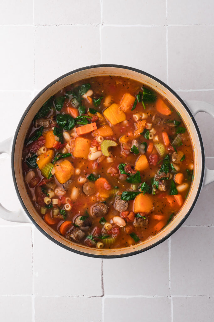 A pot of Sausage Minestrone Soup with the spinach and sausage added.