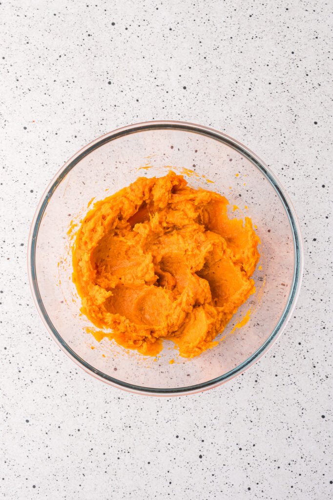 A glass bowl of mashed sweet potatoes.