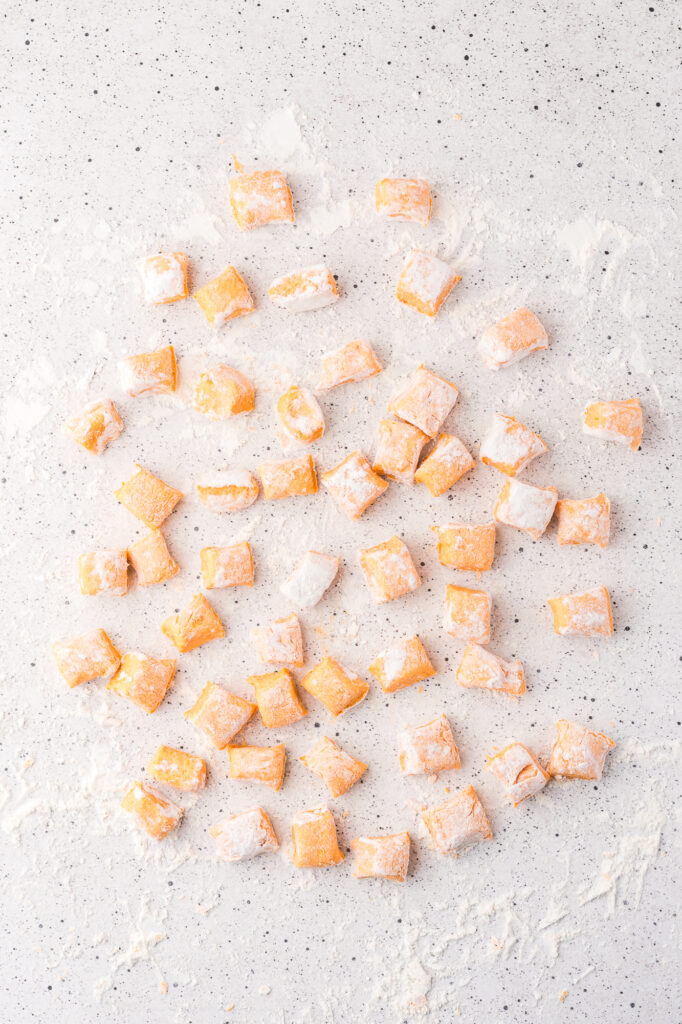 The strips of gnocchi dough cut into gnocchi shapes.