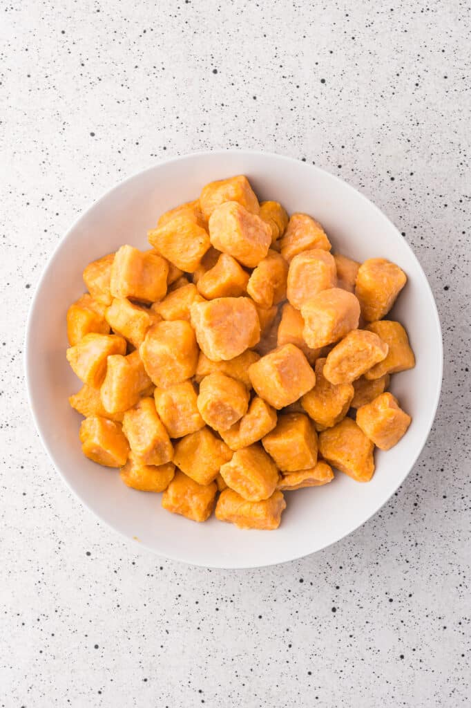 A bowl of boiled/cooked sweet potato gnocchi.