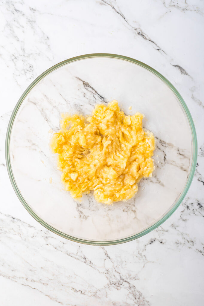 A glass bowl of mashed banans.