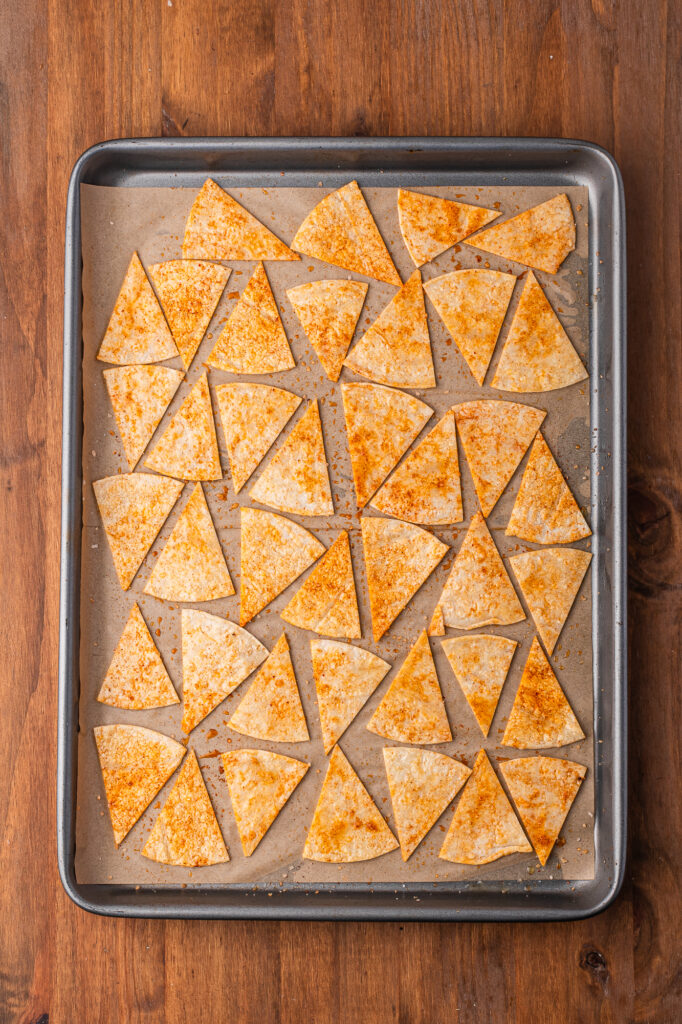 A baking sheet of seasoned tortilla cut into triangle shapes