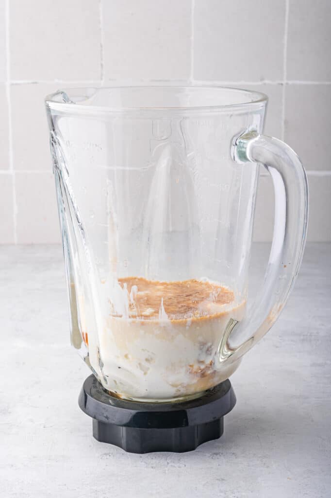 A blender full of ingredients for Ninja Creami Vanilla Cottage Cheese Ice Cream before blending