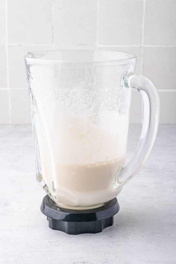 A blender full of ingredients for Ninja Creami Vanilla Cottage Cheese Ice Cream after blending
