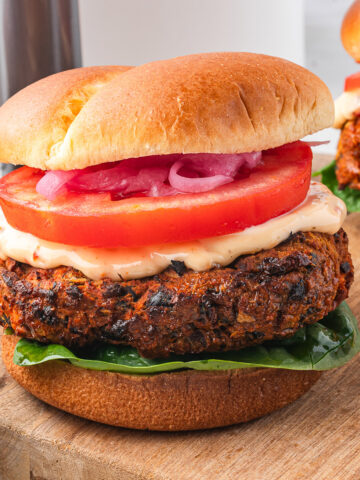 An Air Fryer Sweet Potato and Black Bean Burger with Sun-dried Tomato Aioli on a hamburger bun