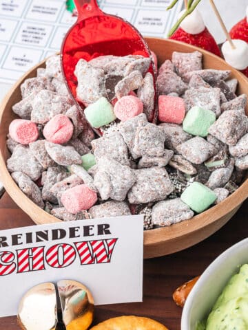 A bowl of Reindeer Chow with a red plastic scoop in it