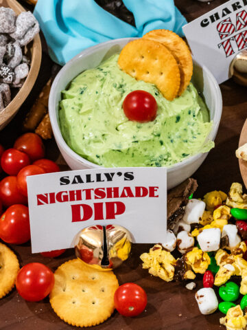 Sally's Nightshade Dip in a bowl with two crackers and a cherry tomato in it
