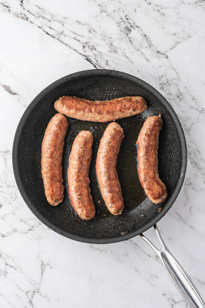 Sausages browning in a pan