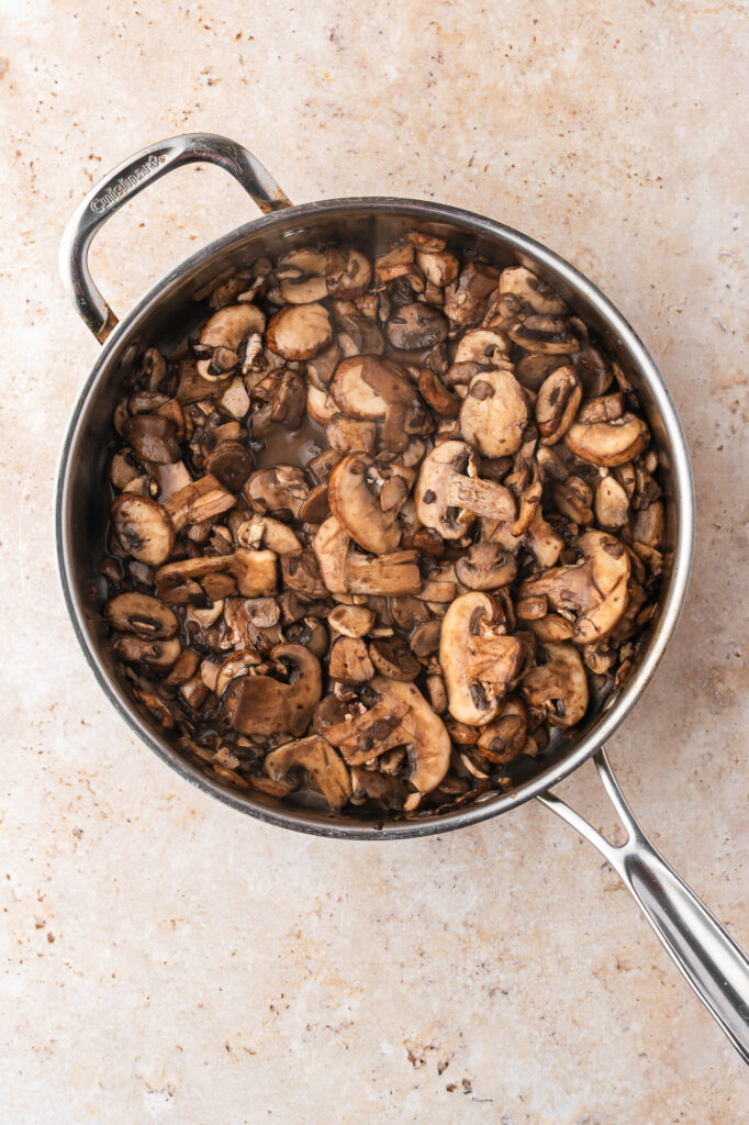 A skillet of sliced mushrooms cooking down