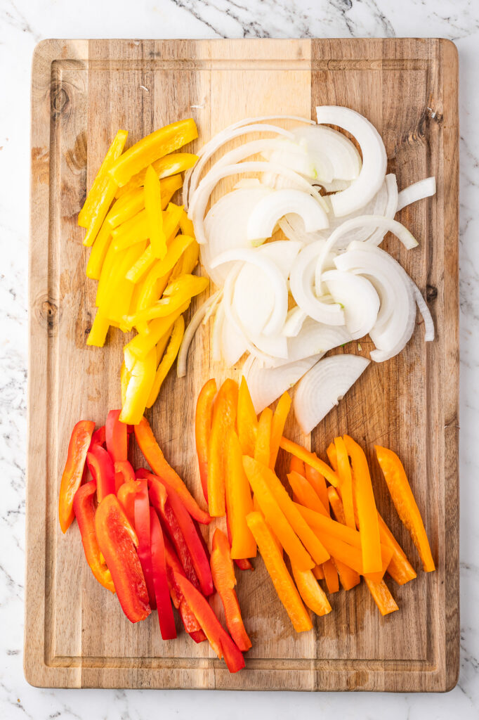 Chopped peppers and onions on a wooden cutting boards