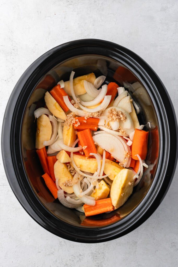 The sliced veggies inside the slow cooker