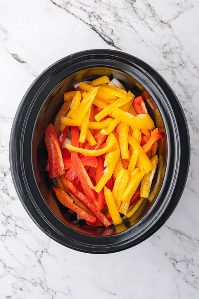 Chopped peppers and onions in a slow cooker