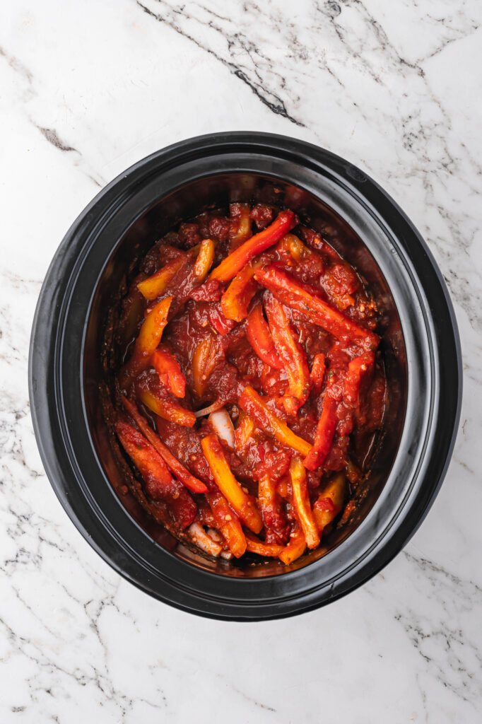 All ingredients for Slow Cooker Sausage and Peppers in the slow cooker before cooking