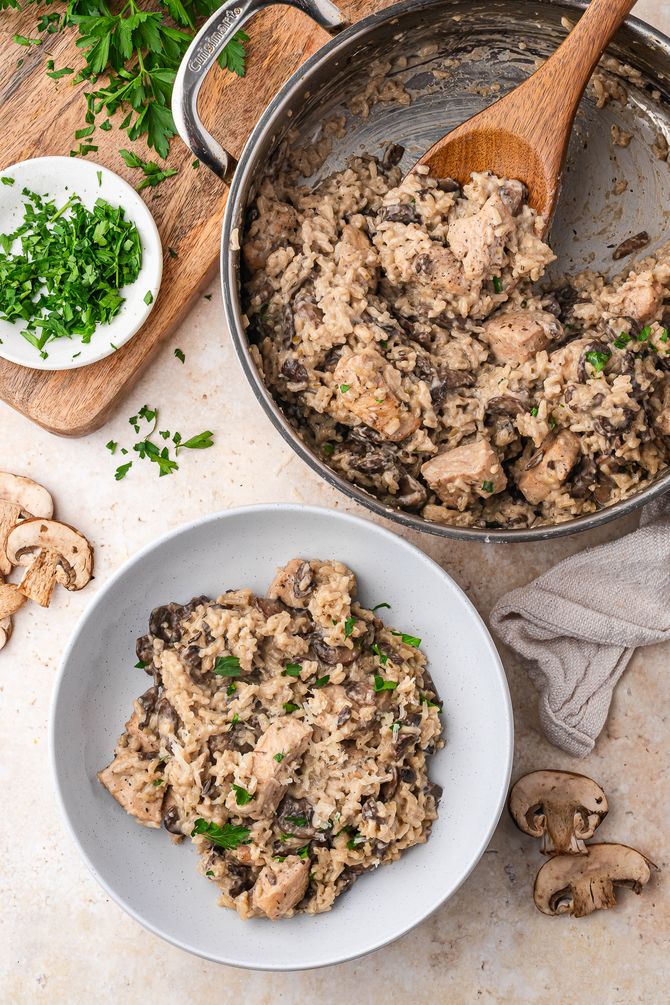 A serving of Creamy Mushroom Chicken and Rice in a bowl next to the skillet of it