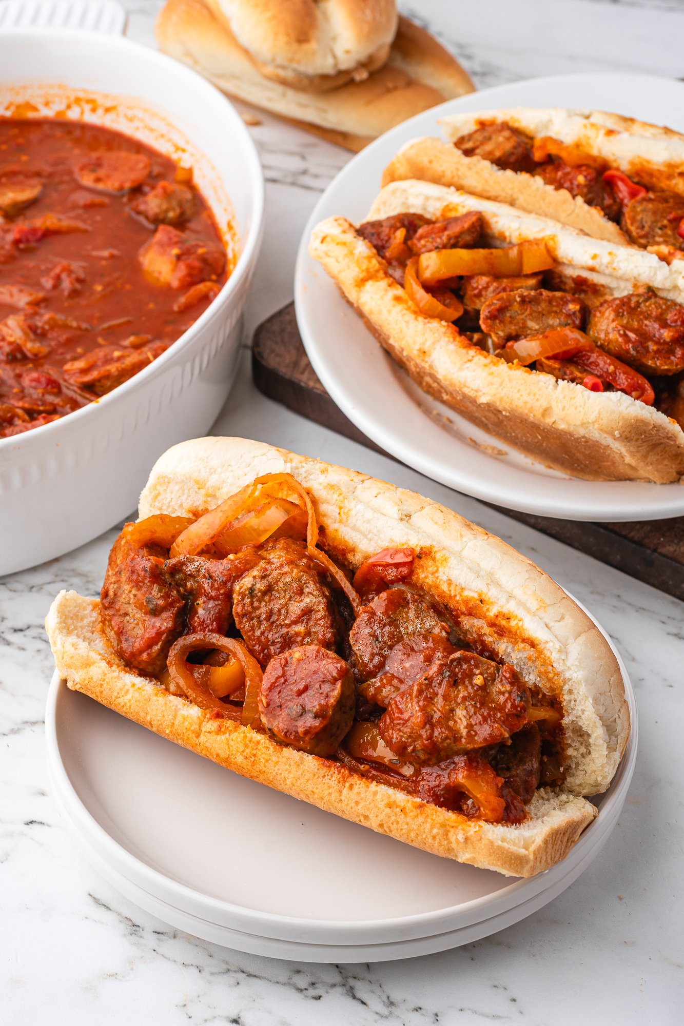 The Slow Cooker Sausage and Peppers being served in hot dog buns