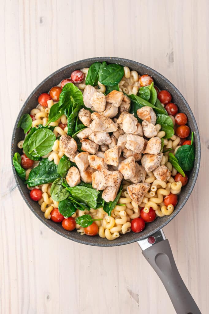 A skillet with all the pre-mixed ingredients for Boursin Cheese Pasta with Chicken