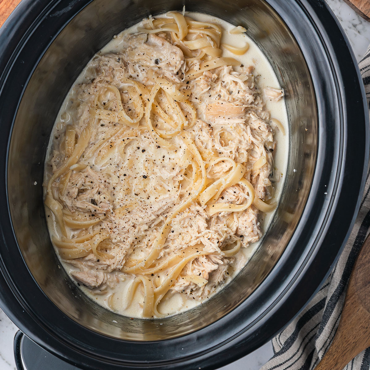 A slow cooker base with cooked Slow Cooker Chicken Alfredo